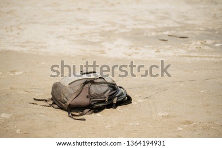 a single backpack deserted on a sandy beach Royalty-Free Stock Photo #1364194931