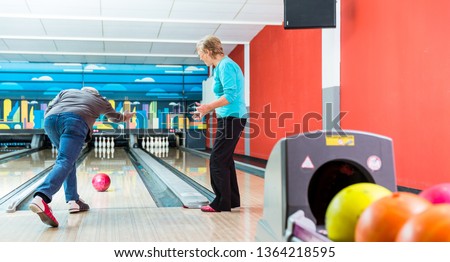 Rear view of a mature man playing bowling game