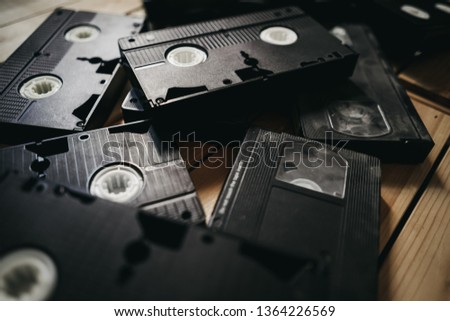  stack of old VHS video tape cassette on wooden table. retro style background image. top view photo.
