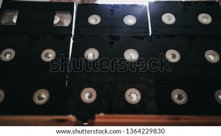 stack of old VHS video tape cassette on wooden table. retro style background image. top view photo.