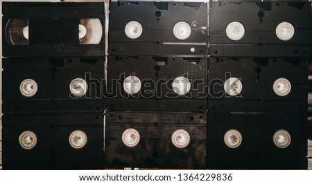 stack of old VHS video tape cassette on wooden table. retro style background image. top view photo.