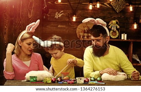 Father, mother and her child enjoy painting Easter eggs. Shop Online for happy easter decoration. Easter eggs - color egg assortment.