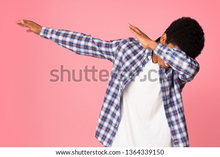 Black guy making dab gesture, having fun on pink studio background
