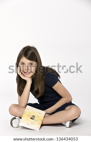 Sitting girl with a copybook with a cat on the cover