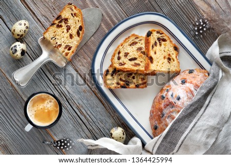Easter Bread (Osterbrot in German). Top view of traditional fruity bread on rustic wood  with fresh leaves and quail eggs. Traditional German dessert for Easter celebration.