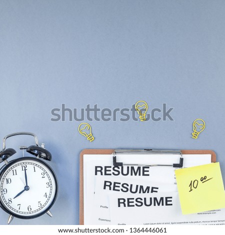 Creative top view flat lay of desk with resume documents and smartphone with copy space on blue background in minimal style. Concept of new job, hiring recruitment process, new team members screening