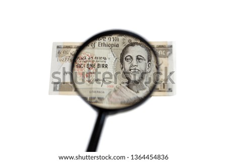 1 Ethiopian birr bank note and magnifying glass isolated on white background