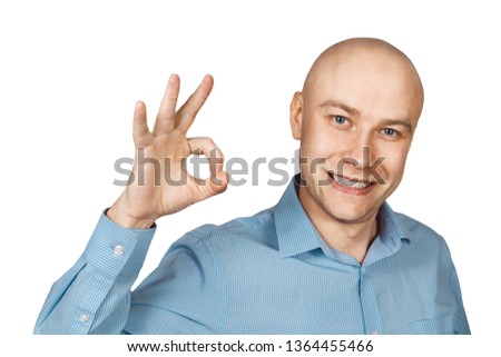 Portrait White bald man in blue shirt on a white isolated background showing sign okay.