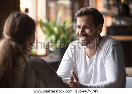 Rear view woman sitting at table in cafe with handsome smiling man, people spends time at meeting searching for soul mate, male telling about himself making good first impression, speed dating concept Royalty-Free Stock Photo #1364479949