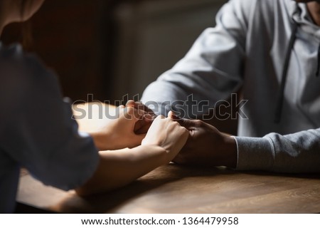 Close up hands african man caucasian woman sitting at table holds hands at romantic speed dating, lovers spend time talking enjoy time together. Multiracial love first sight feelings, support concept Royalty-Free Stock Photo #1364479958