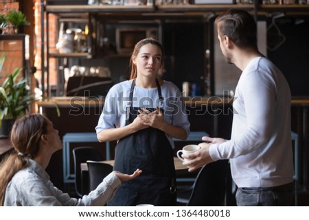 Hostile angry restaurant client couple or friends talking with waiting staff in public place complains about cold coffee long service, spoiled tasteless dish waitress feels guilty mixed orders concept Royalty-Free Stock Photo #1364480018