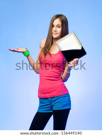 Colorful dressed expressive teen beauty holding tablet computer for copy space.