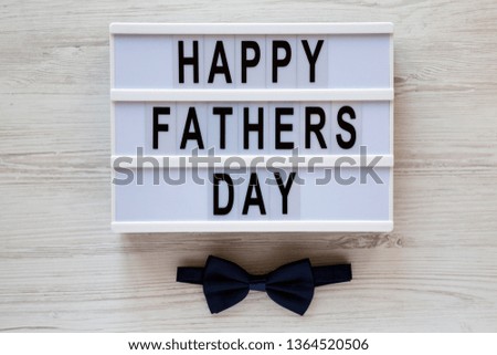 Modern board with 'Happy Fathers Day' words over white wooden surface, top view. Overhead, from above, flat lay. Father's day concept.
