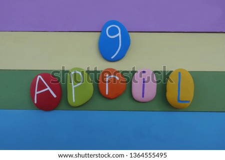 9 April, composed with colored stones over a multi colored wooden board 