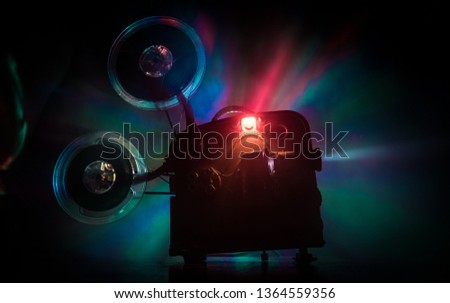 Old vintage movie projector on a dark background with fog and light. Concept of film-making. Selective focus