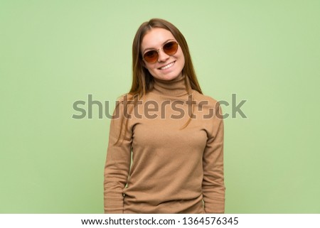 Young woman with turtleneck sweater with glasses and happy