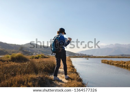 Female backpacker with photo camera enjoy in nature