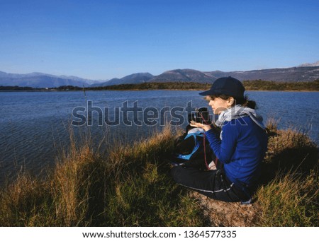 Female backpacker with photo camera enjoy in nature