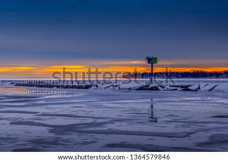 Frozen or ice cover winter landscape in buffalo new york outer harbor sunset at the blue hour.