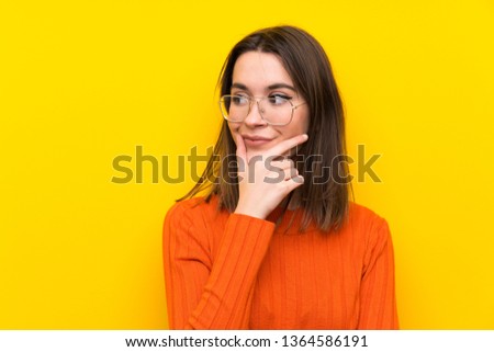 Teenager girl over blue wall thinking an idea