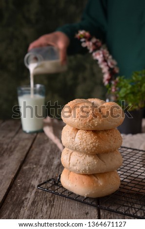 Cream Dinner rolls bread buns with jam and butter. Bottle of milk. Cup of milk.