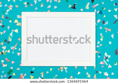White frame on colorful table top view. Mockup for planning birthday or party. Copy space for text. Flat lay. Festive greeting background