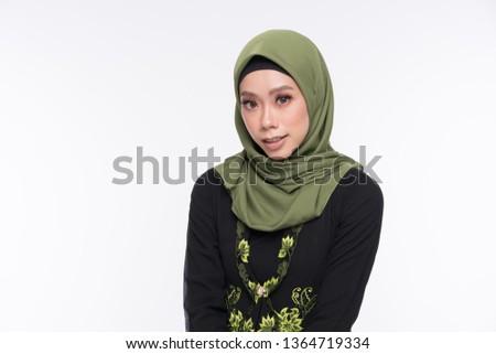 Beautiful female model wearing kebaya, an Asian traditional dress for Muslim woman isolated over white background. Eidul fitri fashion and beauty.