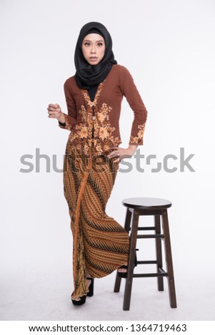 Beautiful female model wearing kebaya, an Asian traditional dress for Muslim woman isolated over white background. Eidul fitri fashion and beauty.