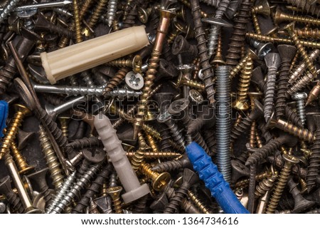 Screws, nuts, bolts, washers  lying on a wooden table. Carpenter screws.  Renovation and constructon conceptual picture.