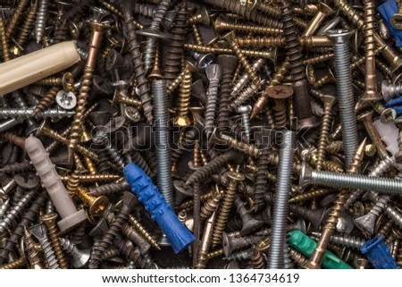 Screws, nuts, bolts, washers  lying on a wooden table. Carpenter screws.  Renovation and constructon conceptual picture.