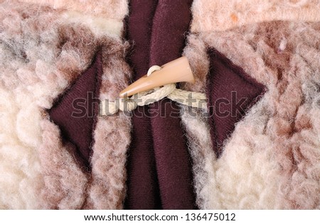 A plastic horn toggle fastener with a rope loop on a vest of a sheepskin