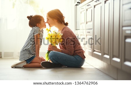 happy mother's day! child daughter congratulates mother and gives a bouquet of flowers to narcissus and gift
