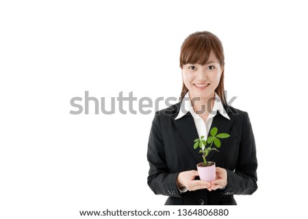 Young business woman holding leaf plant in her hand