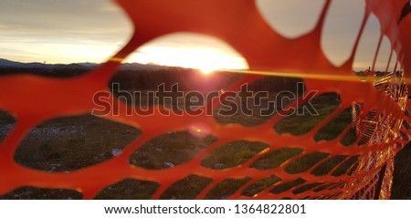 sunset through orange protection net