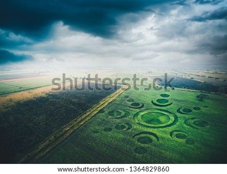 Aerial view of fields with an alien crop circle formation / photo composite Royalty-Free Stock Photo #1364829860