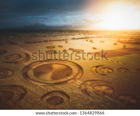 Aerial view of fields with an alien crop circle formation / photo composite Royalty-Free Stock Photo #1364829866