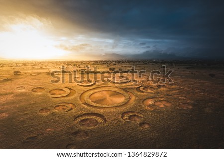 Aerial view of fields with an alien crop circle formation / photo composite Royalty-Free Stock Photo #1364829872