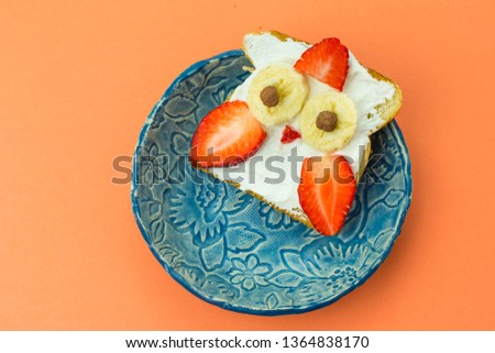 Funny healthy dessert toasted sandwiches with fruits and cream on coral background. Children breakfast, food concept
