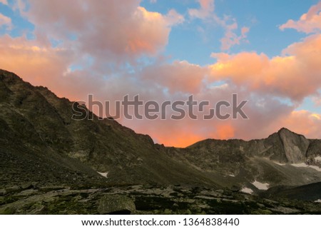Picturesque sunset above the mountains ridge in Akchan valley. Altai Mountains. Russia