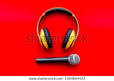 podcast record with microphone and headphones on red background top view