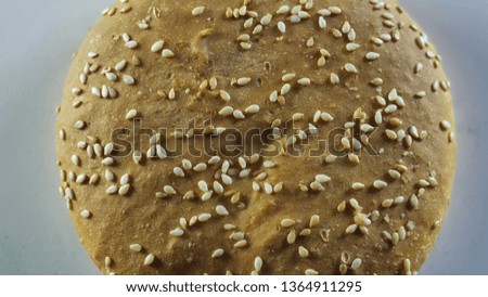 Bun sprinkled with sesame burger rotates around its axis, top view