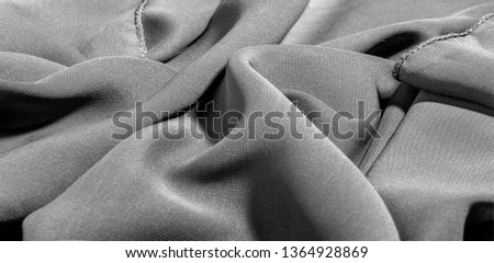 Background texture of silk fabric. This is a natural black scarf, this beautiful nylon satin made of rayon with a transparent hand and a wonderful sheen is perfect for your projects..