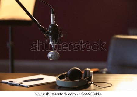 Table with headphones and microphone in radio station