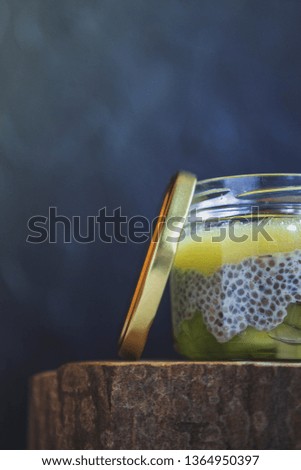 photo for advertising tropical dessert with fruits of kiwi, pineapple, chia, cream cheese, in a jar