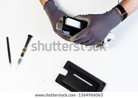 Man Repair Mobile Phone Broken Display Top Down View. Hands in Glove Dismantle Smartphone Crack Glass Cover on White Background. Cellphone Holder Tool Overhead. Telephone Device Fix Isolated Flat Lay