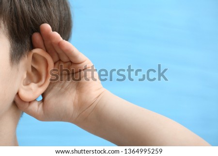 Little boy with hearing problem on color background, closeup
