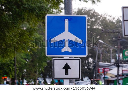 Road sign in the form of a white plane on a blue background