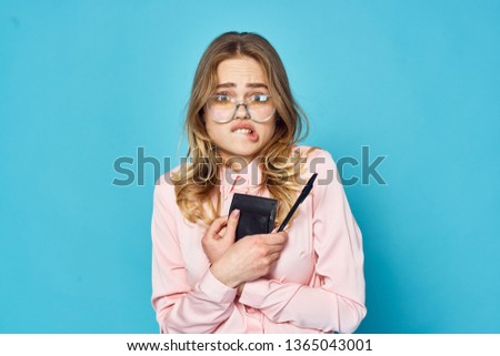 Pretty businesswoman in pink shirt with calculator and pen in hands