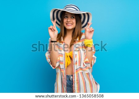 Young woman in bikini in summer holidays with fingers crossing and wishing the best