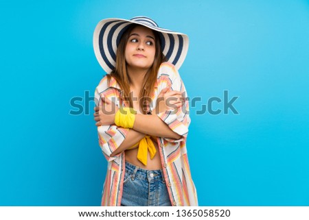 Young woman in bikini in summer holidays making doubts gesture while lifting the shoulders